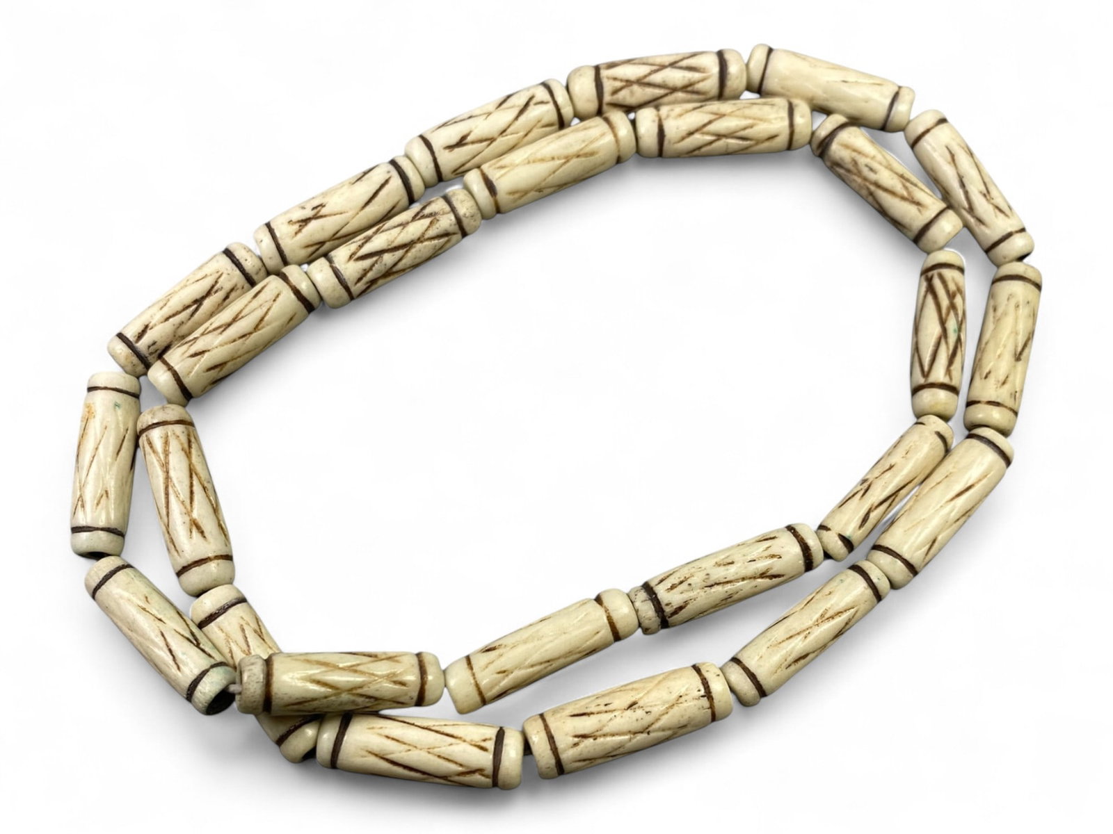 Vintage Tibetan Yak Bone Cylinder Bead Strand Unstrung Diamond Carved Mala Components, c. Mid-20th: This vintage Tibetan strand of yak bone beads, carved into cylindrical forms, carries a refined geometric elegance with its diamond-pattern etching. Dating to the mid-20th century CE, each bead was ca
