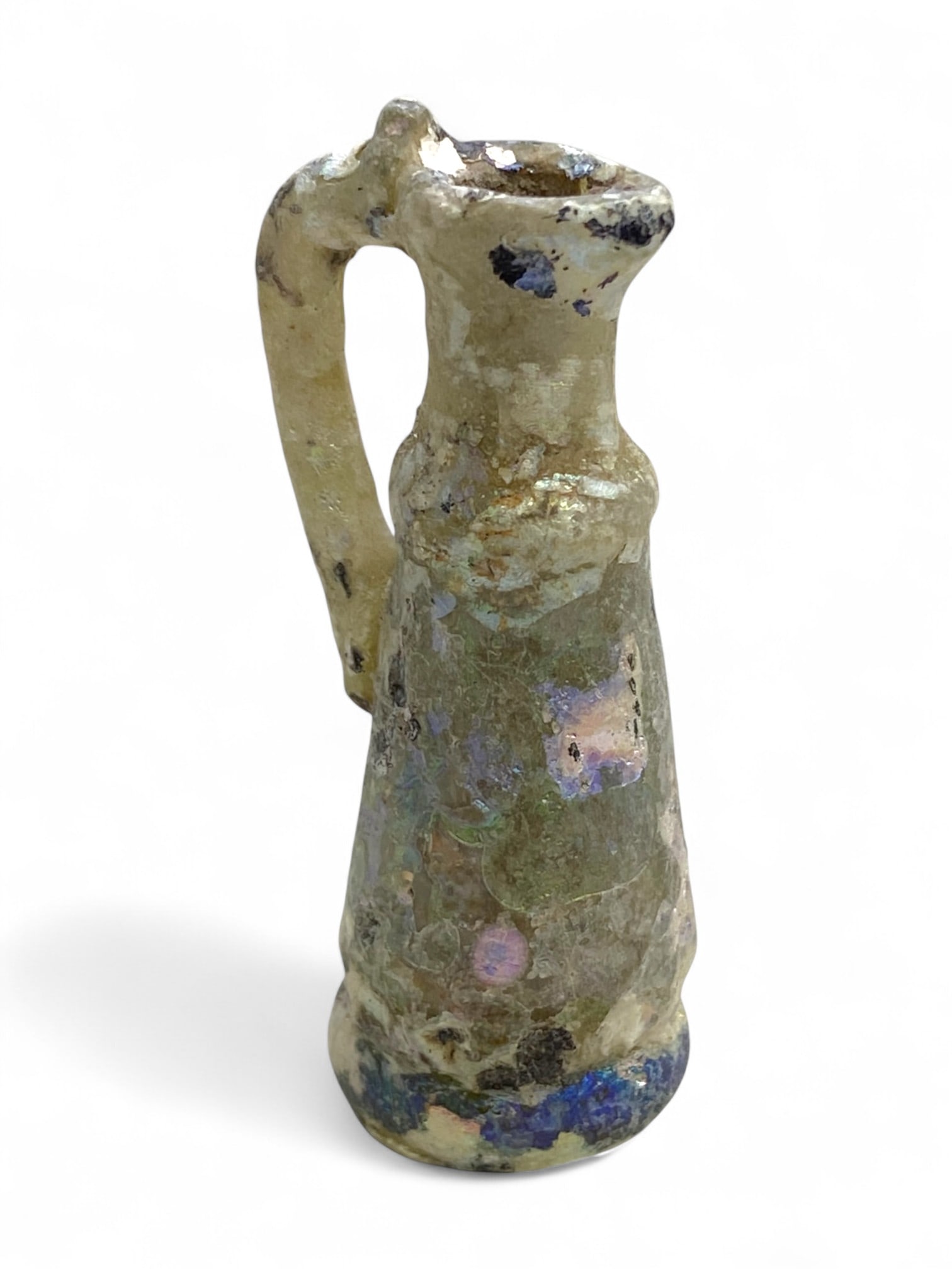 Ancient Roman Iridescent Handled Glass Juglet, c. Flavian Dynasty, Late 1st Century CE, 13g: This miniature Roman glass juglet, formed during the Flavian dynasty in the late 1st century CE, is a rare survivor of one of the empire's most dynamic and artistically experimental periods. Distingui
