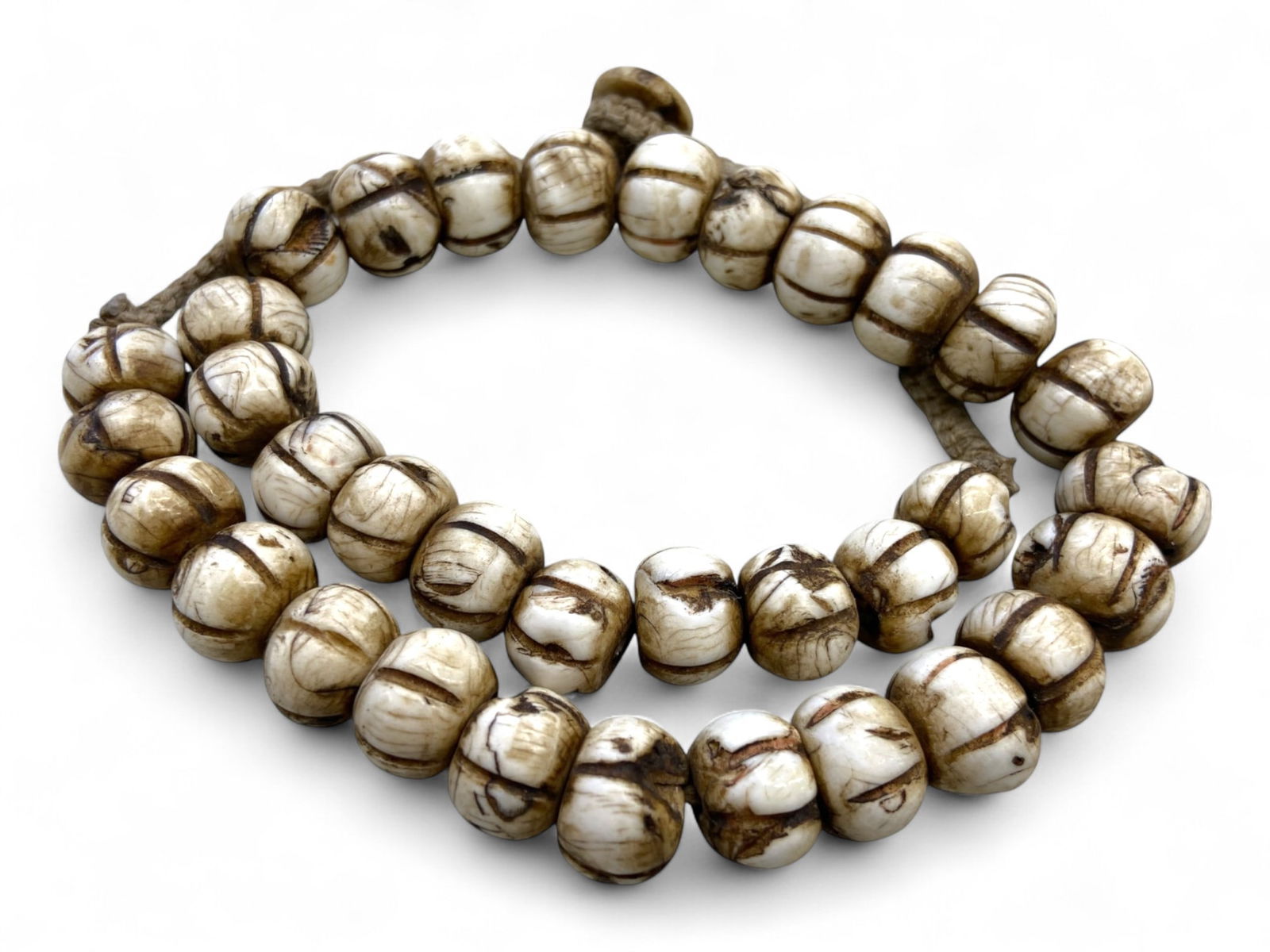 Antique Tibetan Himalayan Dzi-Inspired Etched Bone Prayer Beads Strand, c. 19th Century, 126g: This captivating strand of antique prayer beads from the Tibetan highlands features Dzi-inspired etched bone beads, deeply incised with symmetrical lines and darkened grooves. Dating to the 19th centu