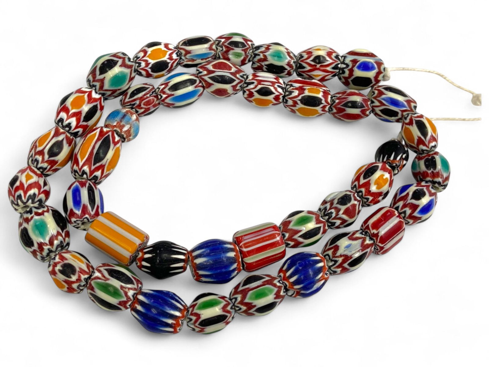 Antique Venetian Chevron & Millefiori Mixed Glass Beads Strand, African Trade, c. 19th-20th Century: An exuberant symphony of color and form, this antique strand brings together some of the most visually captivating glass beads ever produced in Venice during the 19th to early 20th century CE. Combini