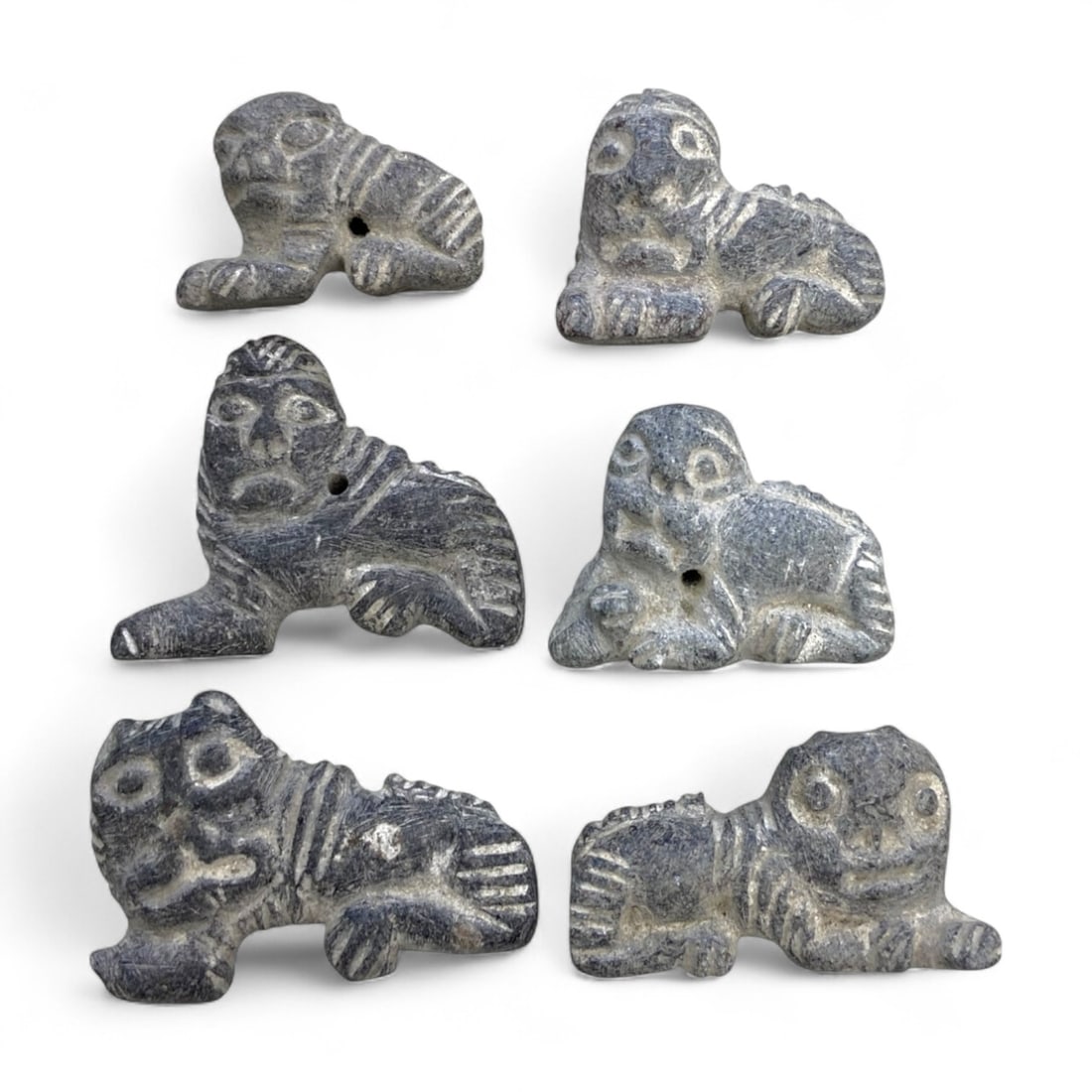 Ancient Near Eastern Reclining Feline Schist Amulet Set of 6, c. 2nd-1st Millennium BCE, 101g: This expressive set of six carved reclining feline amulets, each rendered in gray-black schist with engraved line detail, reflects the artistry and spiritual symbolism of the ancient Near East during