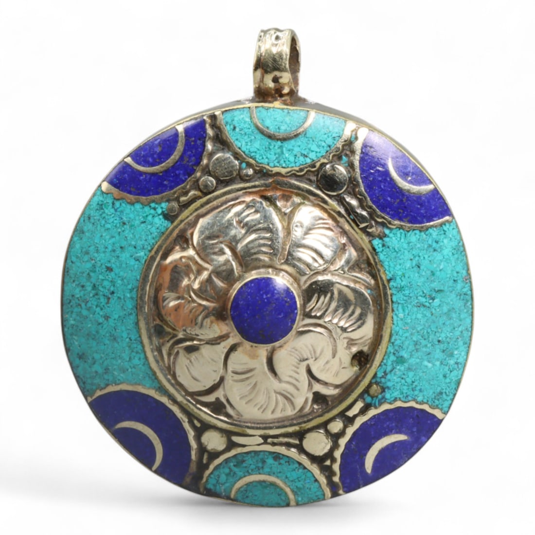 Tibetan Celestial Turquoise Lapis Flower Round Pendant, Himalayan, 42g: This round Tibetan pendant captures a poetic harmony of celestial symbolism and floral elegance, masterfully executed in silver alloy with turquoise and lapis-colored inlay. At its center, a repousse 