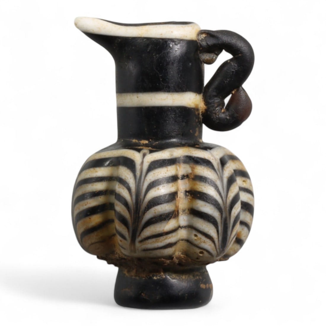 Ancient Early Islamic Abbasid Glass Miniature Juglet, c. 8th-10th Century CE 12g: This elegant glass juglet, measuring 3.3 cm in height and weighing 12 grams, is a refined example of Islamic glasswork from the Abbasid Caliphate (c. 750-1258 CE). Dating specifically to the 8th-10th