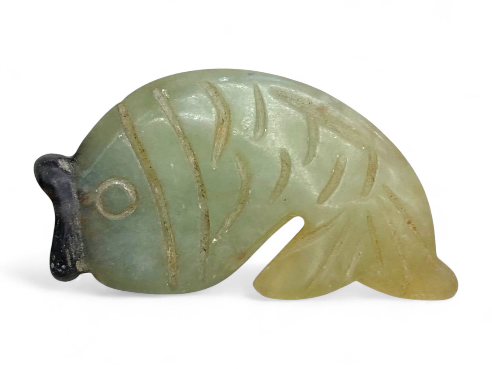 Antique Chinese Jade Fish Amulet Symbolizing Abundance, c. Late Qing Dynasty, 16g: This finely carved Chinese jade fish amulet, dating to the late Qing Dynasty period (late 19th to early 20th century), exemplifies traditional Chinese symbolism and craftsmanship in miniature. Weighin