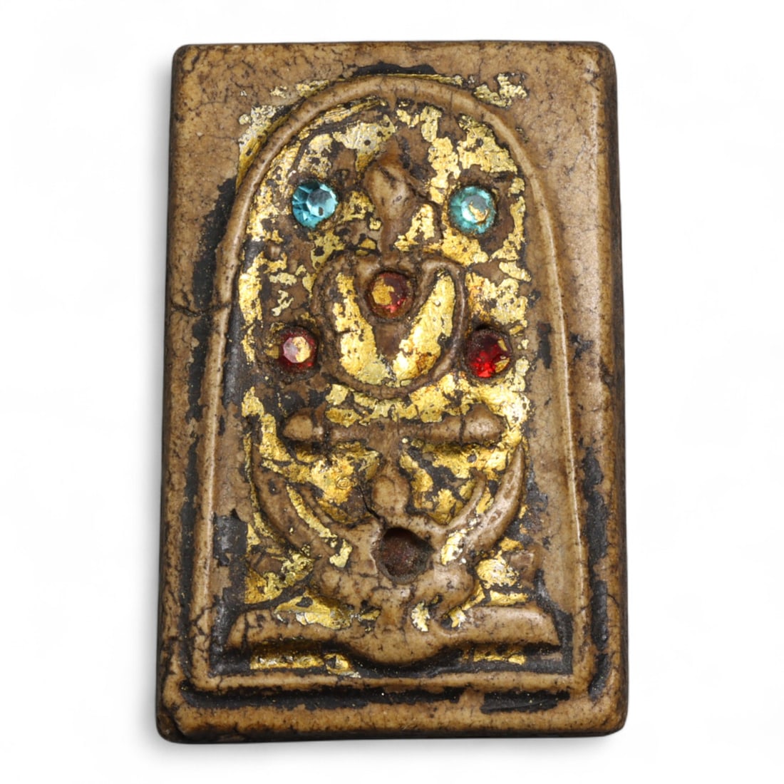 Antique Thai Gilded Terracotta Buddha Amulet with Colored Glass Inlays, c. 19th-20th Century, 25g: This antique Thai terracotta amulet, dating to the 19th-20th century, is richly decorated with remnants of gold leaf and embedded colored glass inlays, lending it a radiant and sacred appearance. The 