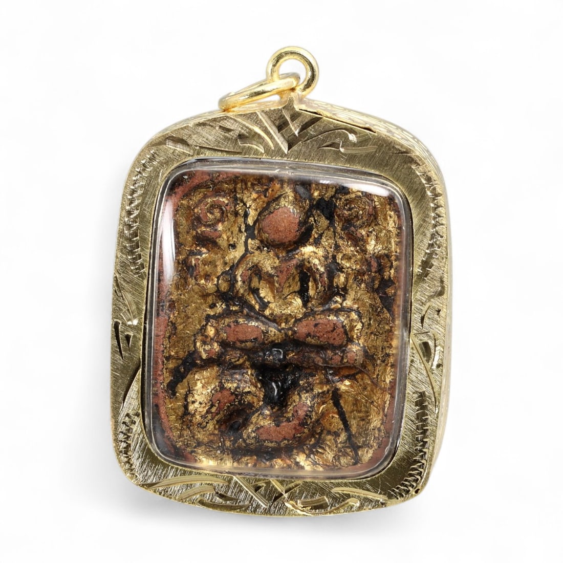 Antique Thai Phra Pidta Powder Amulet with Gold Leaf and Lacquer, c. 19th-20th Century, 14g: This striking antique Thai amulet presents a bold depiction of Phra Pidta, molded from sacred powder and covered with remnants of gold leaf and black lacquer-materials traditionally used in Thai templ