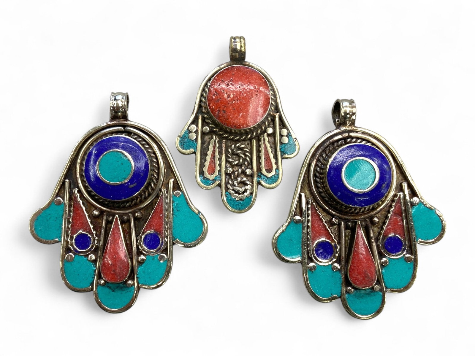 Vintage Himalayan Tribal Turquoise Coral Lapis Silver Pendants, 20th Century, 100g: This set of three vintage Himalayan pendants reflects the colorful and symbolic artistry of tribal jewelry from Nepal and Tibet. Each pendant is crafted in a stylized hand-shaped form, symbolizing ble