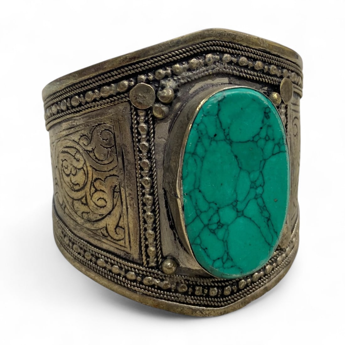 Vintage Himalayan Tribal Turquoise Silver Bracelet, 20th Century, 53g: This vintage Himalayan bracelet highlights the elegance and symbolism of tribal adornment, crafted in silver with repousse decoration and a striking turquoise centerpiece. The large oval cabochon of t