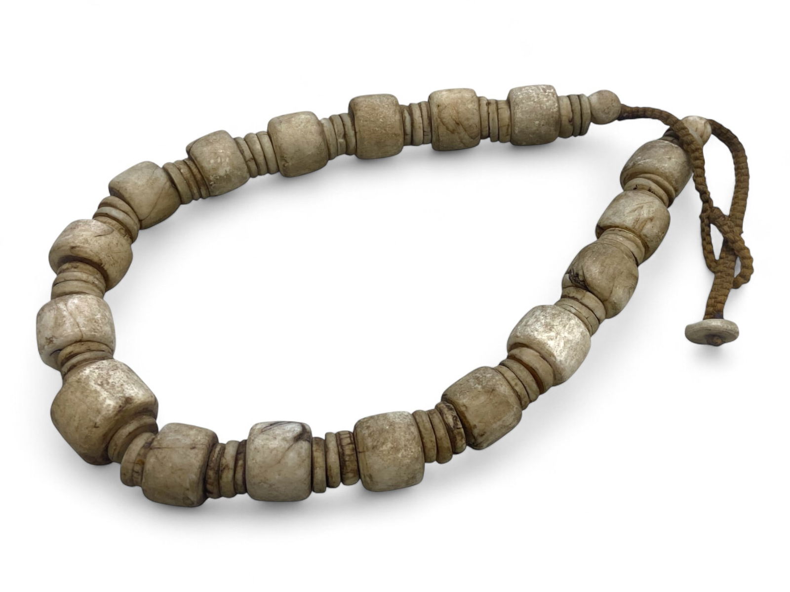 Antique Himalayan Carved Bone Heirloom Beads Necklace, c. 17th-19th Century CE: This striking necklace of ancient Tibetan or Himalayan origin features a dramatic composition of hand-carved bone beads in graduated sizes and forms, ranging from squared barrel beads to interspersed