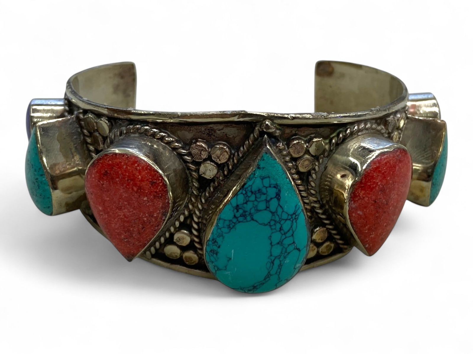 Vintage Himalayan Gilded Brass Cuff Bracelet with Coral and Turquoise Teardrops, 145g: This bold and expressive vintage Himalayan cuff bracelet is a celebration of sacred color, elemental form, and tribal artistry. Likely made in the mid to late 20th century, the bracelet features alter