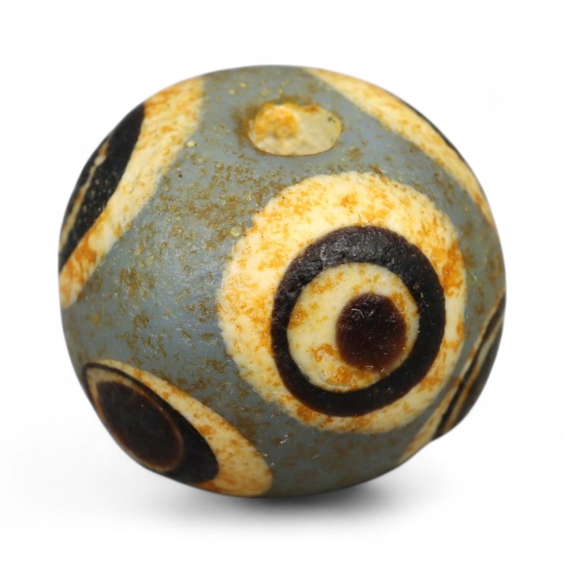 Ancient Roman Stratified Glass Eye Bead, c. 1st-3rd Century CE, 1.2cm: This finely crafted Roman glass eye bead, dating from the 1st to 3rd century CE, measures 1.2 cm in diameter. Formed through stratified layers of colored glass, it displays concentric circular "eye" m