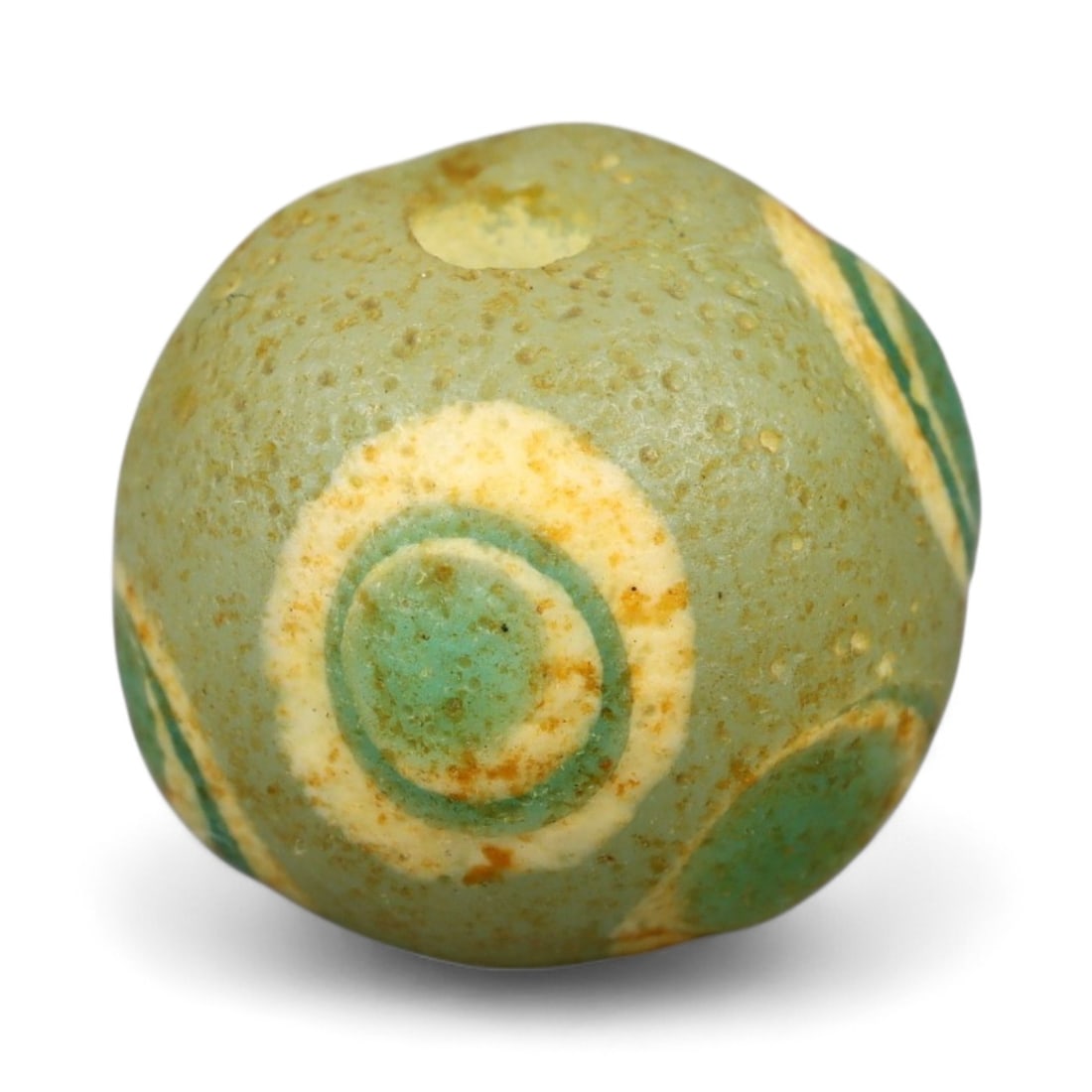 Ancient Roman Stratified Glass Eye Bead, c. 1st-3rd Century CE, 1.2cm: This finely crafted Roman glass eye bead, dating from the 1st to 3rd century CE, measures 1.2 cm in diameter. Formed through stratified layers of colored glass, it displays concentric circular "eye" m