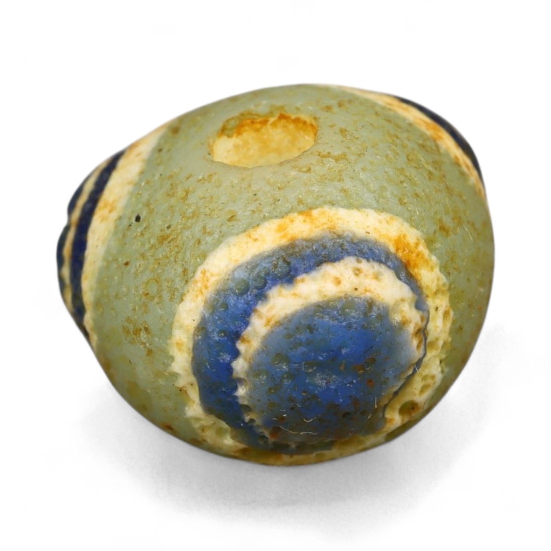 Ancient Roman Stratified Glass Eye Bead, c. 1st-3rd Century CE, 1.2cm: This finely crafted Roman glass eye bead, dating from the 1st to 3rd century CE, measures 1.2 cm in diameter. Formed through stratified layers of colored glass, it displays concentric circular "eye" m