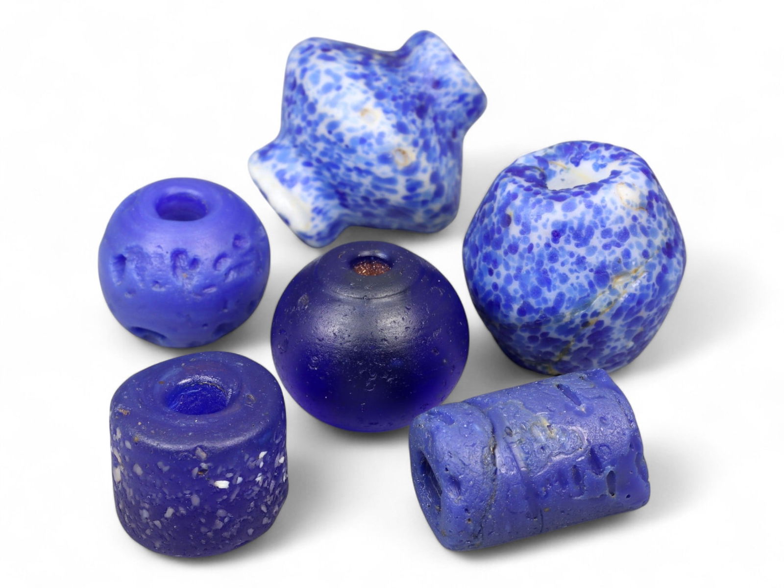 Antique Islamic Blue Glass Bead Collection, Assorted Forms, c. 18th-19th Century CE, 1.5-2cm: This vibrant group of six antique glass beads, dating from the 18th-19th century CE, exemplifies the enduring artistry of Islamic glassmakers. Ranging in size from 1.5 to 2 cm, the beads display a str