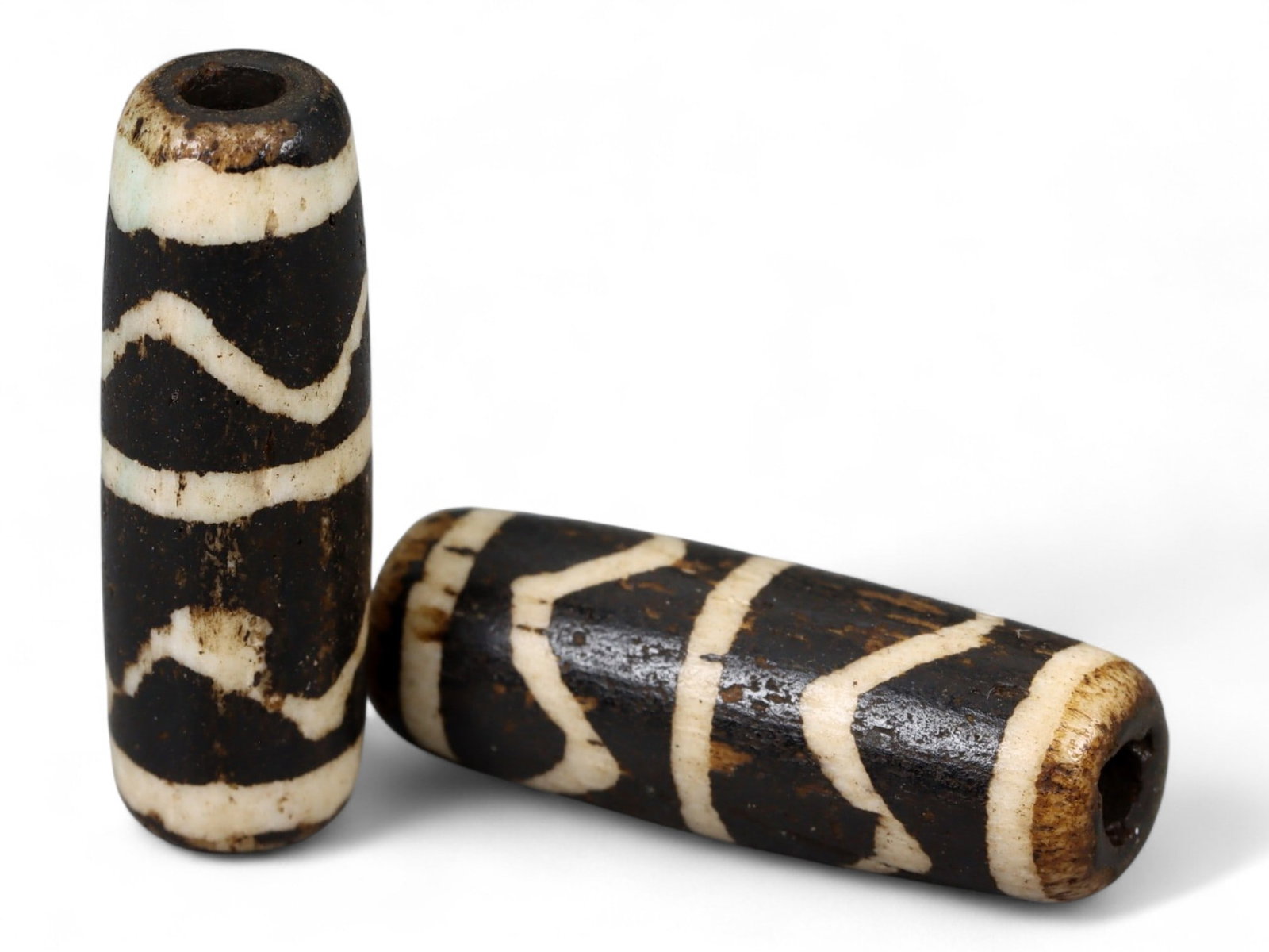 Antique Pyu Pumtek Fossilized Palmwood Cylinder Bead Pair, c. 18th-19th Century CE, 2.4cm: This pair of antique Pumtek beads, crafted from fossilized palm wood, embodies the enduring artistic and spiritual traditions of the Pyu culture of Burma (modern Myanmar). Dating to the 18th-19th cent