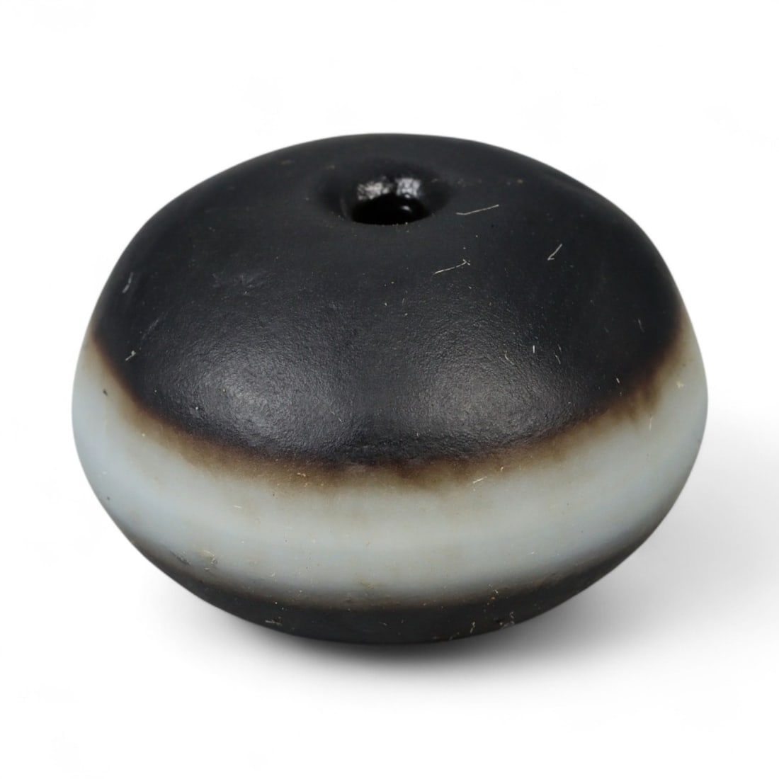 Ancient Tibetan Luk Mik Goat Eye Agate Guru Bead, c. 7th-10th Century CE, 2cm: This striking bead, carved from dark banded agate, represents the Tibetan Luk Mik or "Goat Eye" form, a sacred type of Dzi bead. Dating between the 7th and 10th century CE, this bead reflects the deep