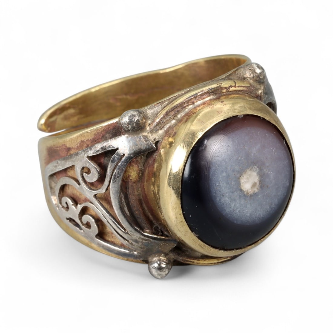 Vintage Himalayan Luk Mik Goat Eye Dzi Silver Gilt Ring, 20th Century: This powerful Himalayan ring, crafted in the 20th century, is set with a Luk Mik "Goat Eye" dzi stone cabochon in a wide silver gilt band with silver decorative accents. The dzi stone displays its cha