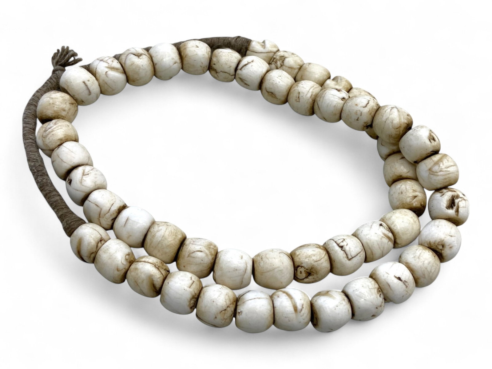 Antique Tibetan White Carved Bone Mala Beads Strand, c. 19th Century, 172g: This serene and substantial antique Tibetan mala strand, dating to the 19th century, is composed of hand-carved white bone beads exhibiting smooth, rounded forms and subtle marbling. Likely made from 