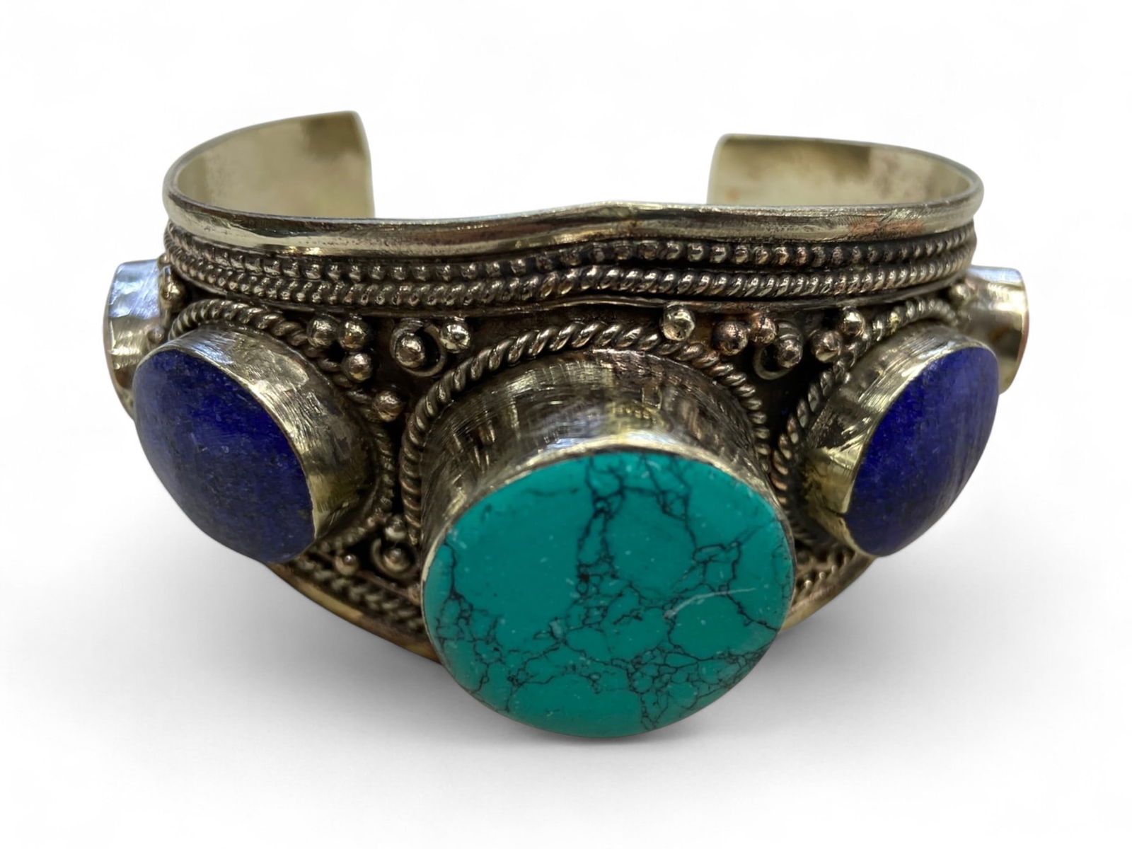 Vintage Himalayan Tibetan Tribal Bangle Bracelet, c. 20th Century, 140g: Himalayan Tibetan bangles of this type represent a distinctive form of tribal adornment, blending bold design with deep cultural symbolism. Typically crafted from mixed metals and set with prominent r