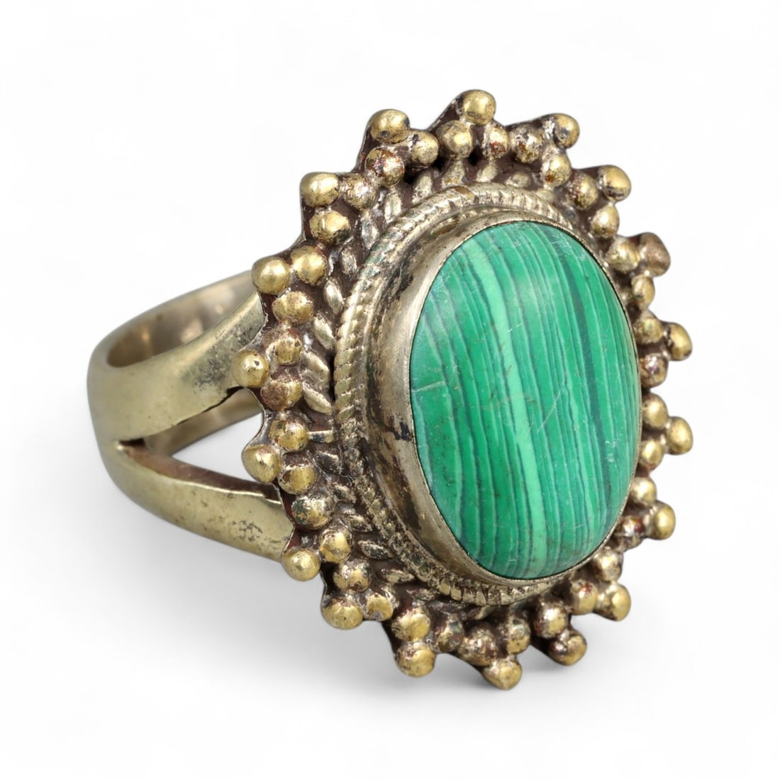 Vintage Tibetan Malachite Silver Gilt Ring, 20th Century, US Size 10.5: This vintage Tibetan ring exemplifies the ornate splendor of Himalayan jewelry design, crafted in silver gilt with a bold presence. At its heart is an oval malachite cabochon, displaying vivid green h
