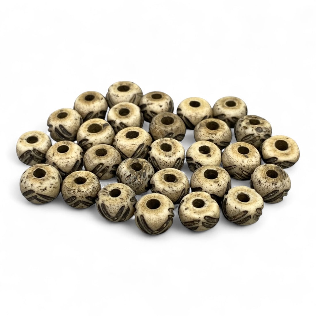 Vintage Tibetan Hand-Carved Bone Beads, c. 20th Century, 1cm: This collection of vintage Tibetan bone beads embodies the spiritual artistry of Himalayan craftsmanship from the 20th century. Handmade by local artisans, each bead carries the organic warmth of natu