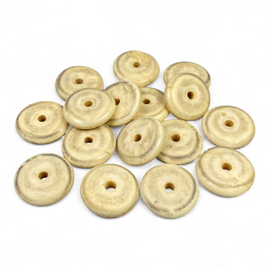 Vintage Tibetan Hand-Carved Bone Beads, c. 20th Century, 2cm: This collection of vintage Tibetan bone beads embodies the spiritual artistry of Himalayan craftsmanship from the 20th century. Handmade by local artisans, each bead carries the organic warmth of natu