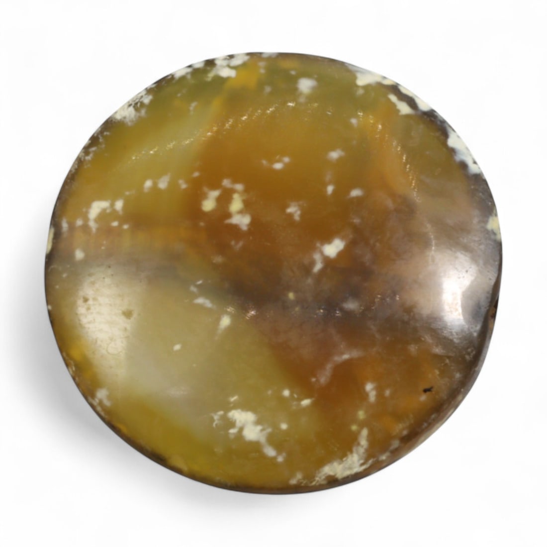 Ancient Mesopotamian Carnelian Disc Amulet, c. 2nd-1st Millennium BC, 2.5cm, 5g: This small disc-shaped amulet, carved from mottled red carnelian with pale mineral inclusions, measures 2 cm in diameter and weighs 3 grams. Its simple, rounded form reflects the enduring lapidary tra