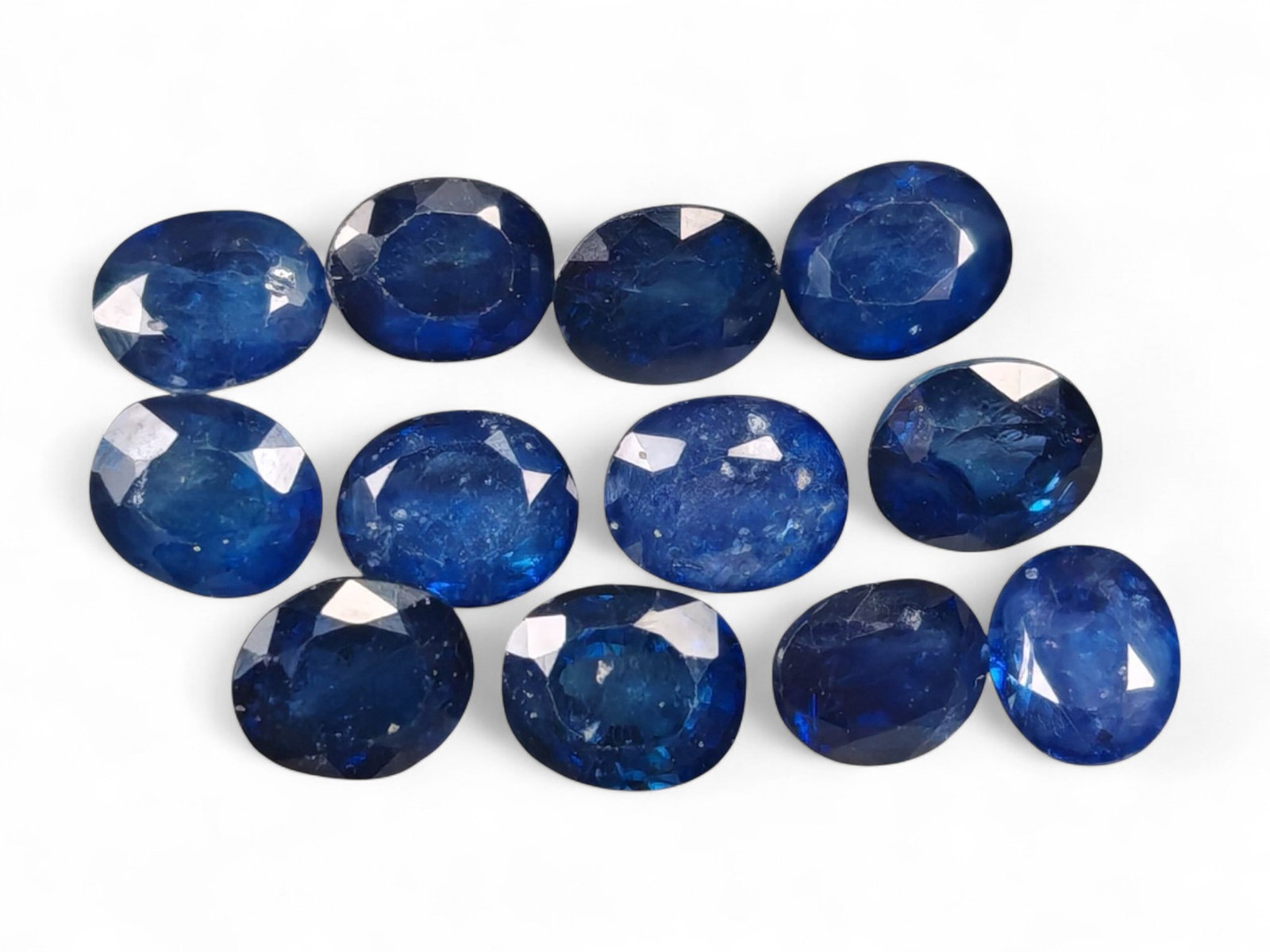 9.93 Carats Royal Blue Sapphire Oval Lot - Natural Ceylon Stones: This captivating lot of oval-cut sapphires exhibits a deep royal blue color, rich and even, with flashes of lighter brilliance across the facets. Each stone, measuring approximately 6x5x2.8mm, is grac