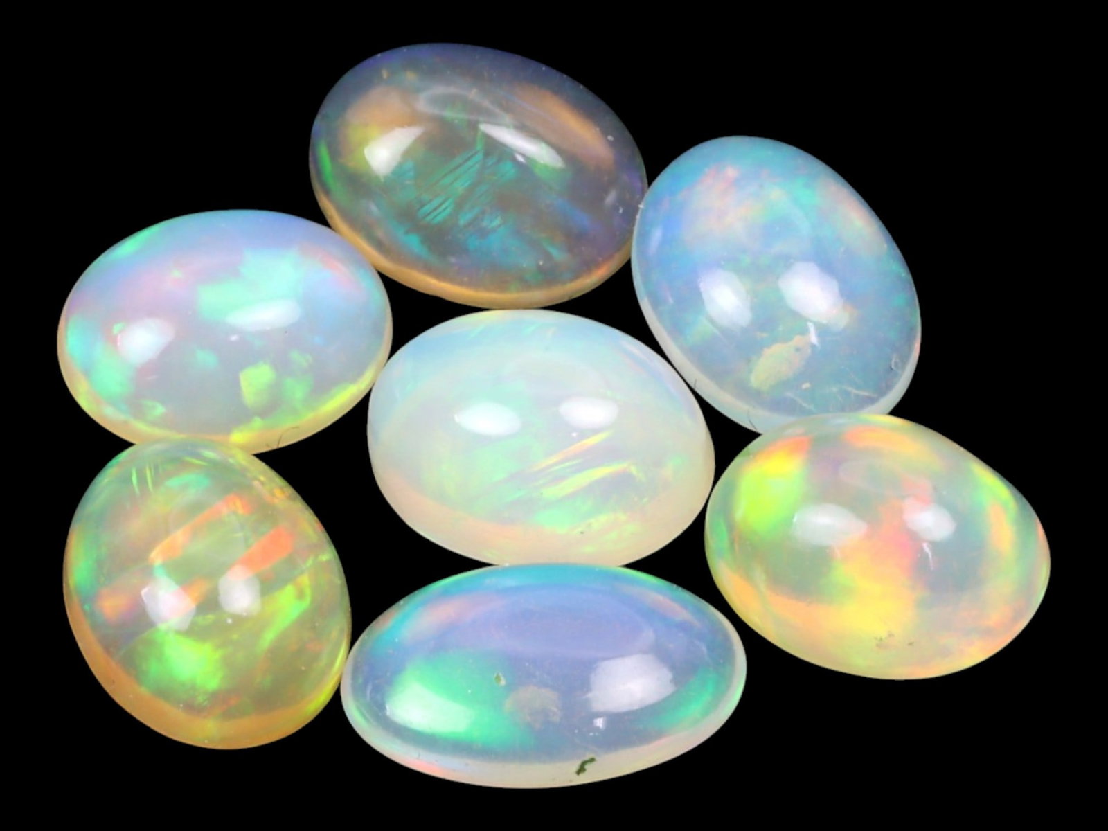 8.47 Carats Multi-Color Welo Opal Lot - Natural Ethiopian Stones: This radiant group of Welo opals displays a mesmerizing interplay of color that dances across the surface with every shift of light. Electric flashes of green, orange, and red ripple through a translu