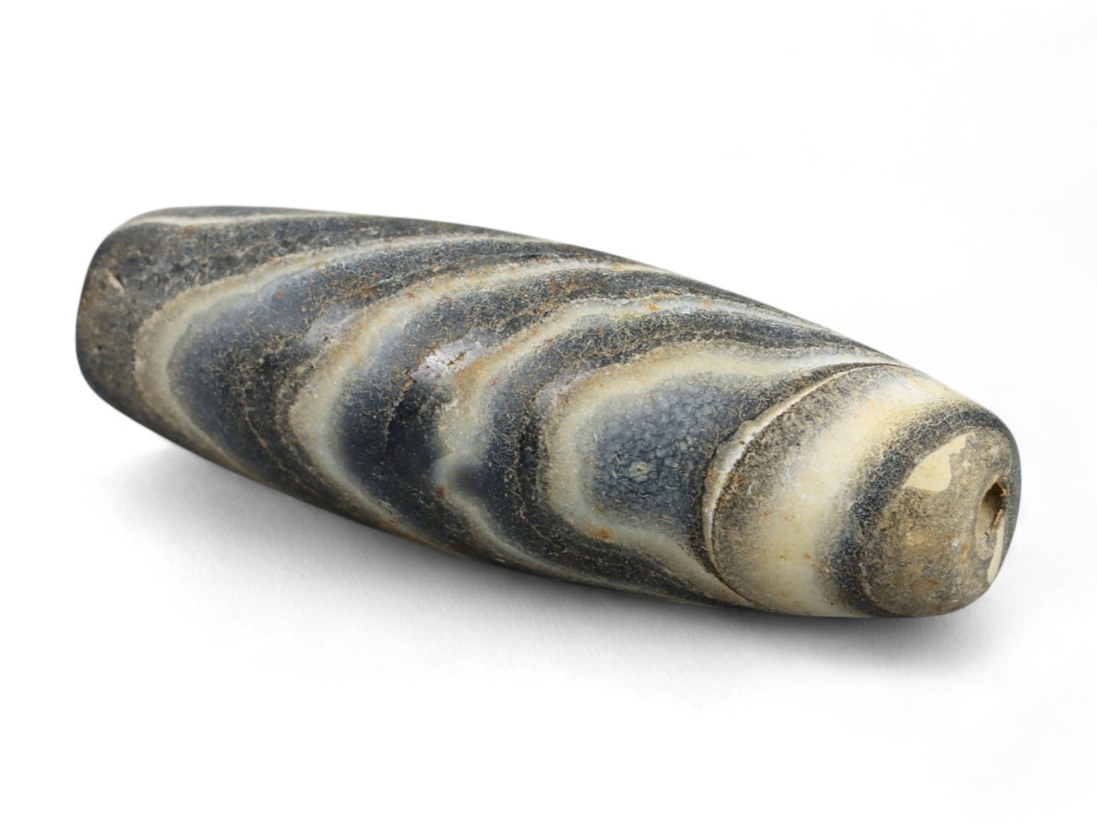 Ancient Gandhara Banded Sulaimani Agate Bead, c. 1st-3rd Century CE, 3cm: This striking banded agate bead, often referred to as a Sulaimani bead, originates from the Gandhara region, c. 1st-3rd century CE, during the height of the Kushan Empire. Gandhara, straddling present