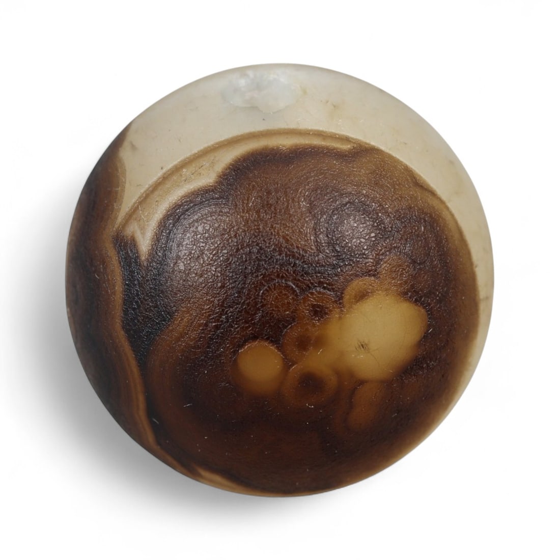 Ancient Himalayan Eye Agate Dzi Bead, c. 3rd-7th Century CE, 1.8cm: This remarkable spherical bead, measuring 2 cm, belongs to the class of ancient Dzi beads that have long been revered in Tibet and the wider Himalayan world. Its defining feature is the concentric "ey