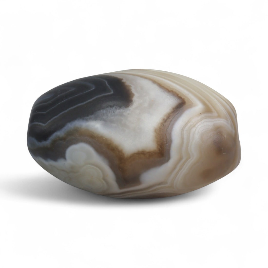 Antique Himalayan Banded Agate Amulet Bead, c. 15th-17th Century, 2.5cm: This bead, carved from banded agate with smoky brown and gray tones, dates to the Himalayan region between the 15th and 17th centuries. Its elongated oval form, shows concentric layering, a characteri