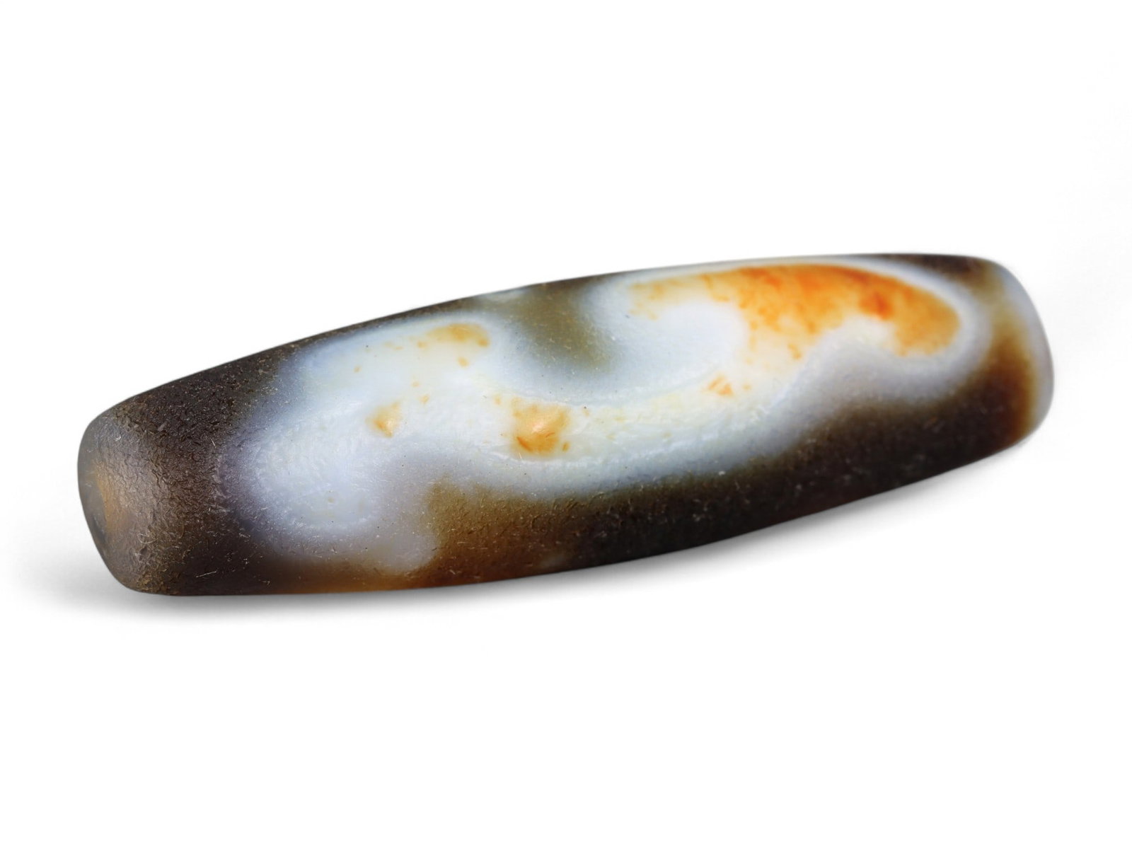 Ancient Tibetan Himalayan Banded Agate Dzi Bead, c. 9th-14th Century CE, 4cm: This ancient Tibetan Dzi bead, measuring 2.6 cm, is carved from richly banded agate, its surface revealing bold layers of deep red, amber, and ivory-white. Its elongated cylindrical form, tapering at 