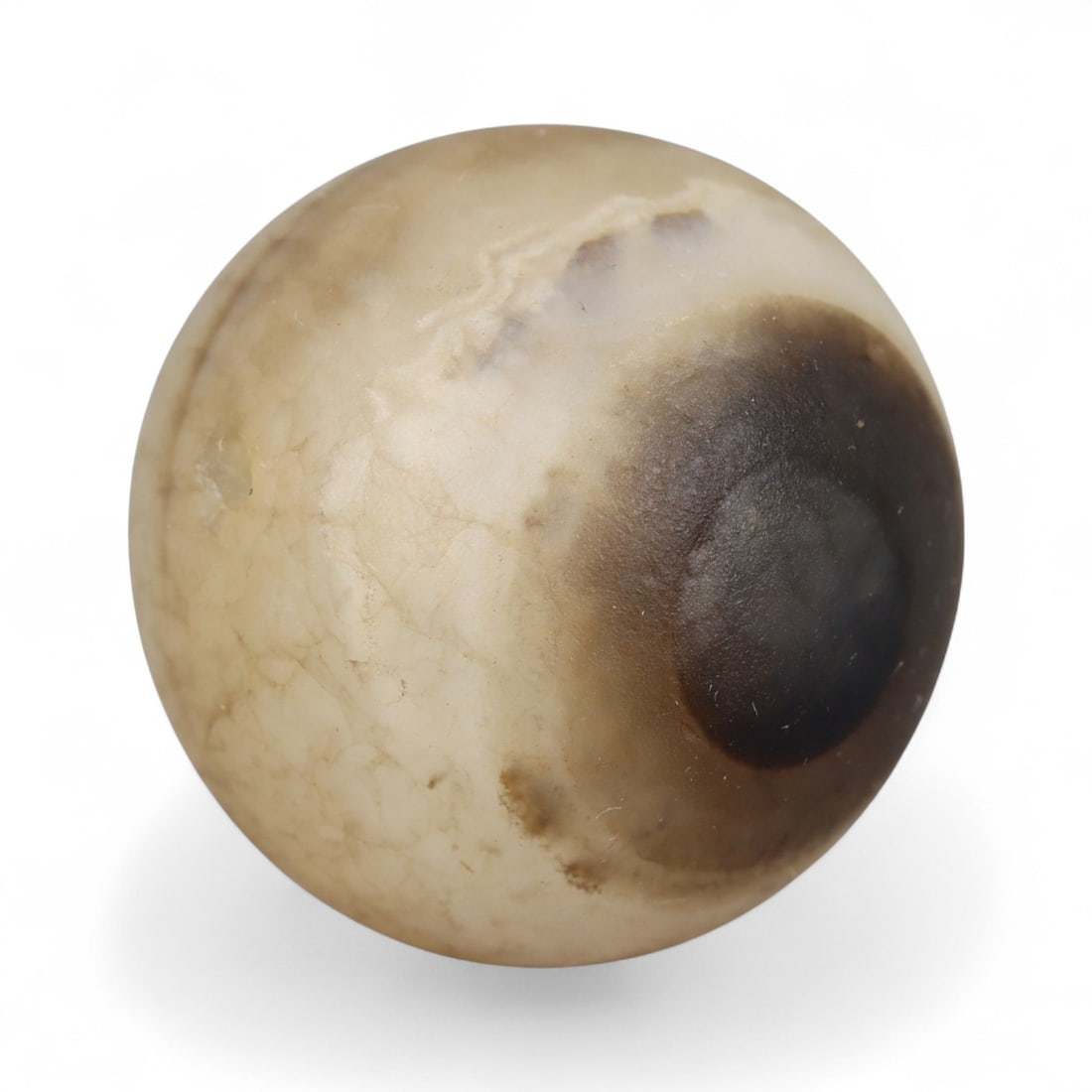 Ancient Himalayan Eye Agate Dzi Bead, c. 3rd-7th Century CE, 2cm: This remarkable spherical bead, measuring 2 cm, belongs to the class of ancient Dzi beads that have long been revered in Tibet and the wider Himalayan world. Its defining feature is the concentric "ey