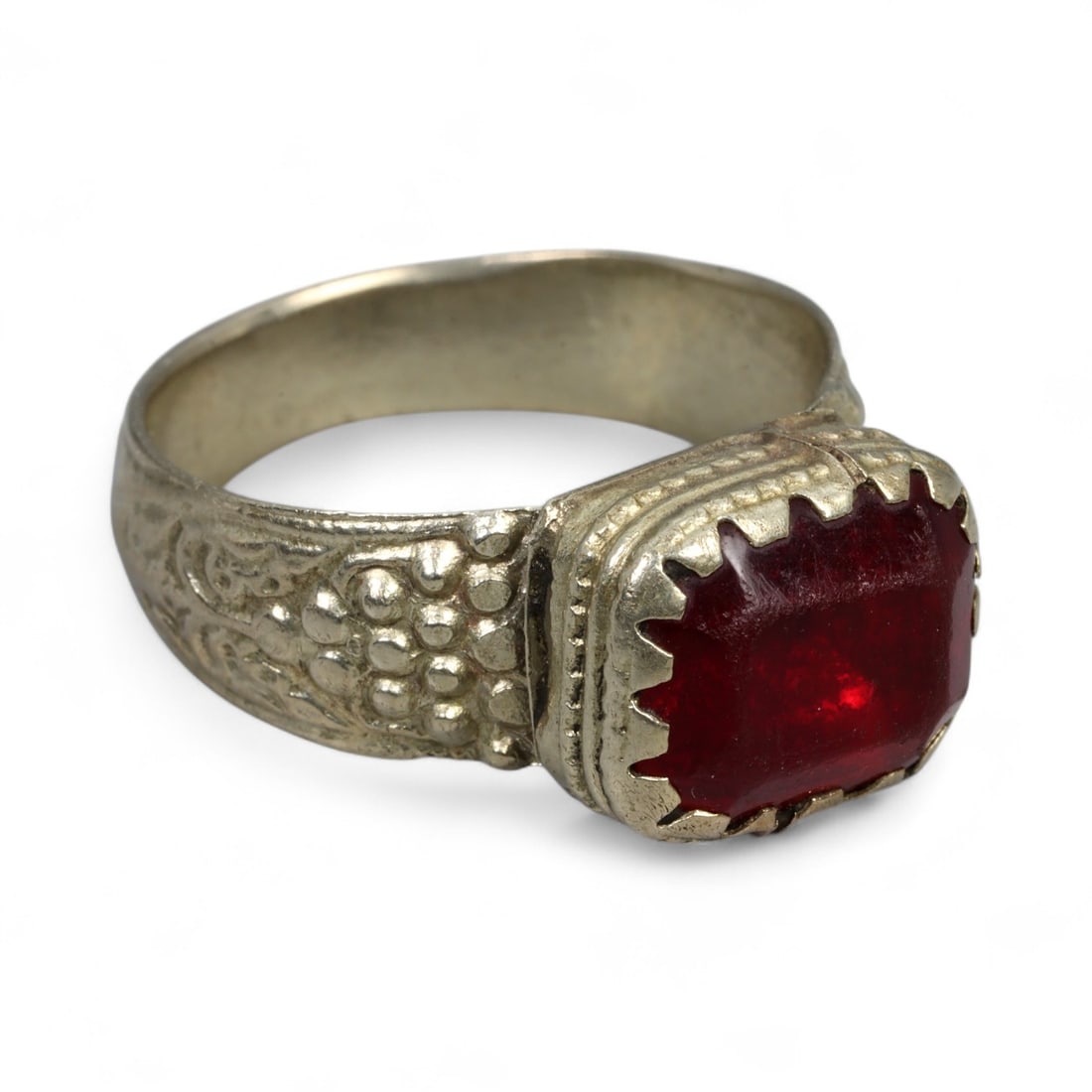 Antique Central Asian Silver Ring with Rectangular Red Glass, c. 19th-20th Century, 5.7g: This antique silver ring from Central Asia reflects the bold, geometric jewelry traditions of the 19th to early 20th century. Its rectangular bezel holds a deep red glass stone, faceted to catch the l