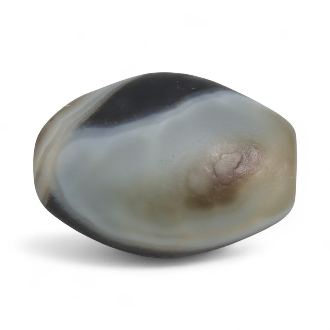 Antique Himalayan Banded Agate Amulet Bead, c. 15th-17th Century, 2.3cm: This bead, carved from banded agate with smoky brown and gray tones, dates to the Himalayan region between the 15th and 17th centuries. Its elongated oval form, shows concentric layering, a characteri