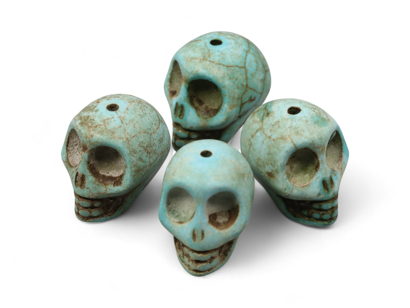 Vintage Tibetan Turquoise Skull Beads, Set of Four, c. Mid-20th Century, 1.7cm: This striking set of four turquoise-carved skull beads, originates from Tibet and dates to the mid-20th century. Finely shaped and perforated for stringing, each bead represents a human skull, a motif