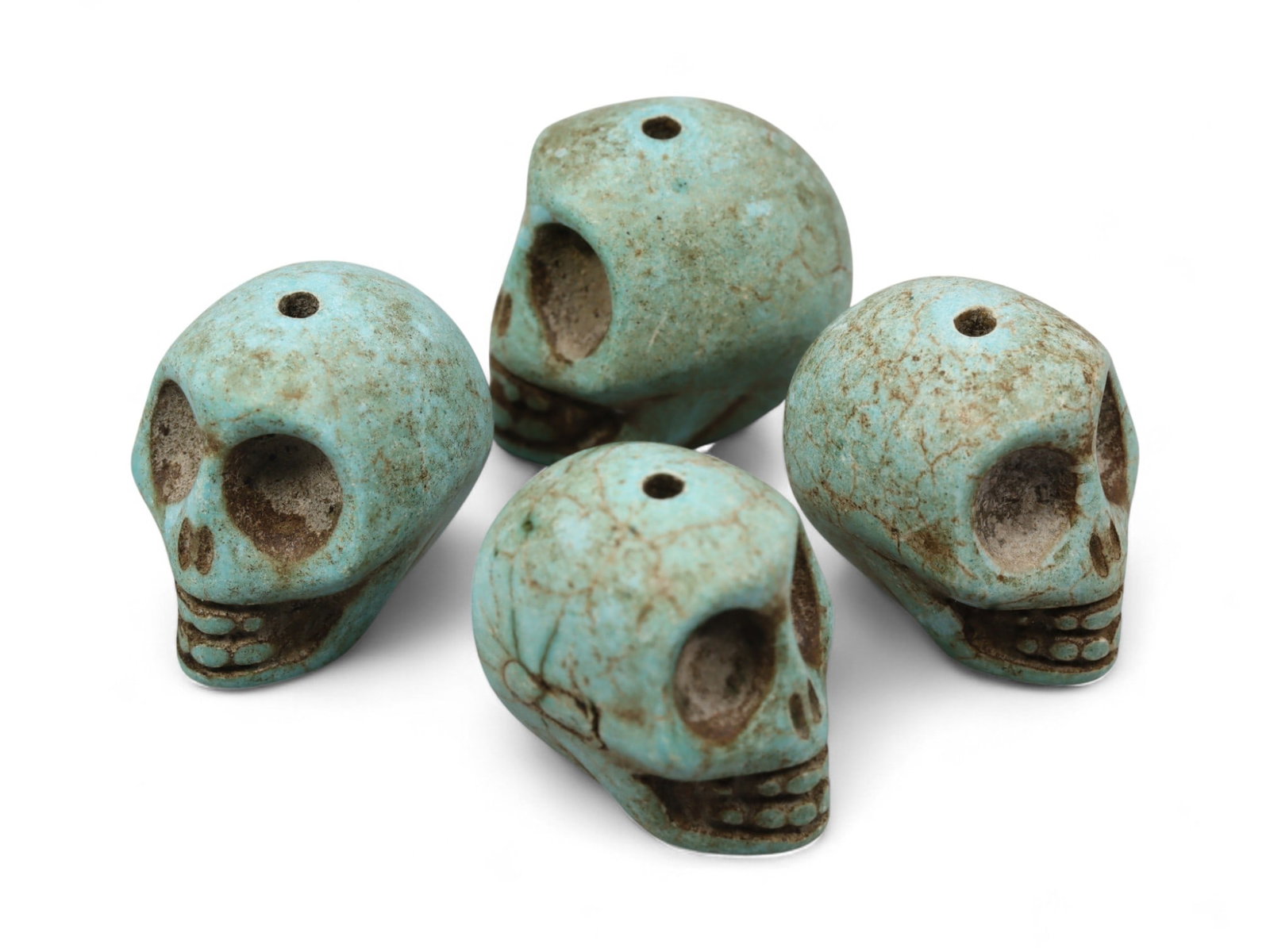 Vintage Tibetan Turquoise Skull Beads, Set of Four, c. Mid-20th Century, 1.7cm: This striking set of four turquoise-carved skull beads, originates from Tibet and dates to the mid-20th century. Finely shaped and perforated for stringing, each bead represents a human skull, a motif