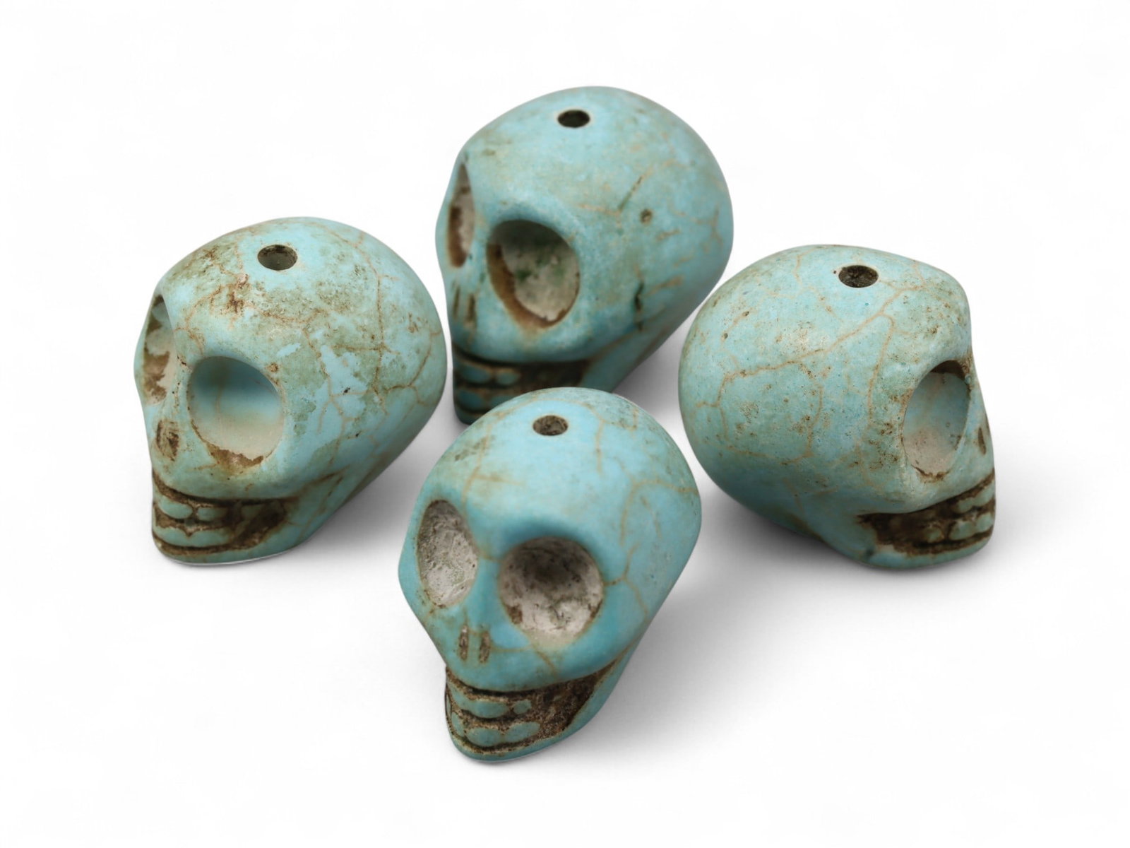 Vintage Tibetan Turquoise Skull Beads, Set of Four, c. Mid-20th Century, 1.7cm: This striking set of four turquoise-carved skull beads, originates from Tibet and dates to the mid-20th century. Finely shaped and perforated for stringing, each bead represents a human skull, a motif