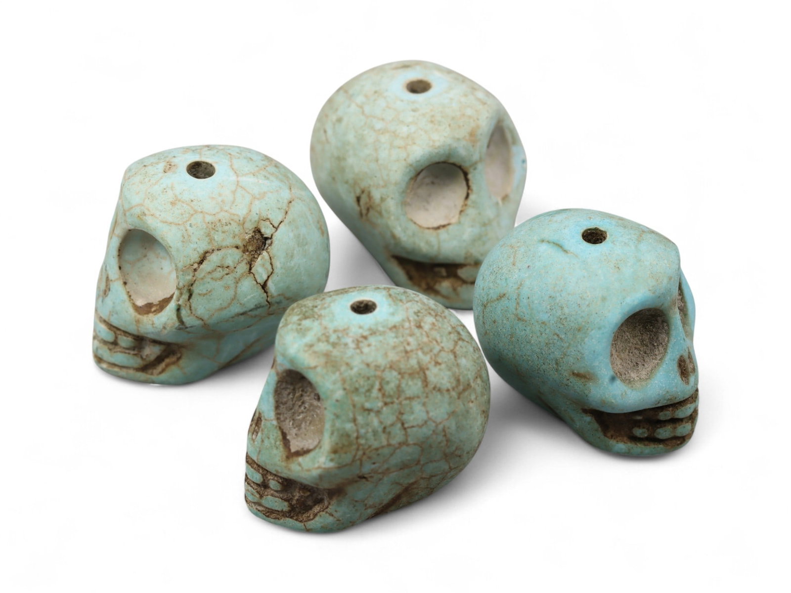 Vintage Tibetan Turquoise Skull Beads, Set of Four, c. Mid-20th Century, 1.7cm: This striking set of four turquoise-carved skull beads, originates from Tibet and dates to the mid-20th century. Finely shaped and perforated for stringing, each bead represents a human skull, a motif