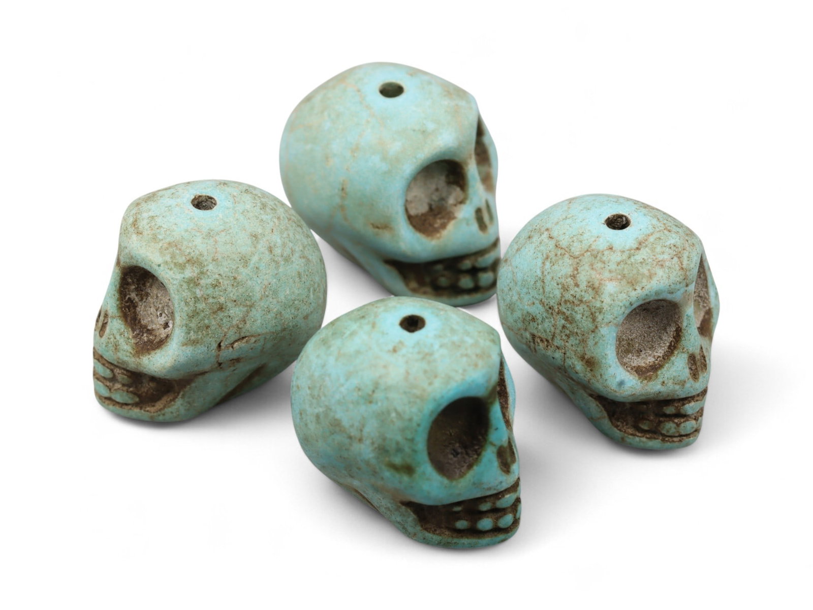 Vintage Tibetan Turquoise Skull Beads, Set of Four, c. Mid-20th Century, 1.7cm: This striking set of four turquoise-carved skull beads, originates from Tibet and dates to the mid-20th century. Finely shaped and perforated for stringing, each bead represents a human skull, a motif