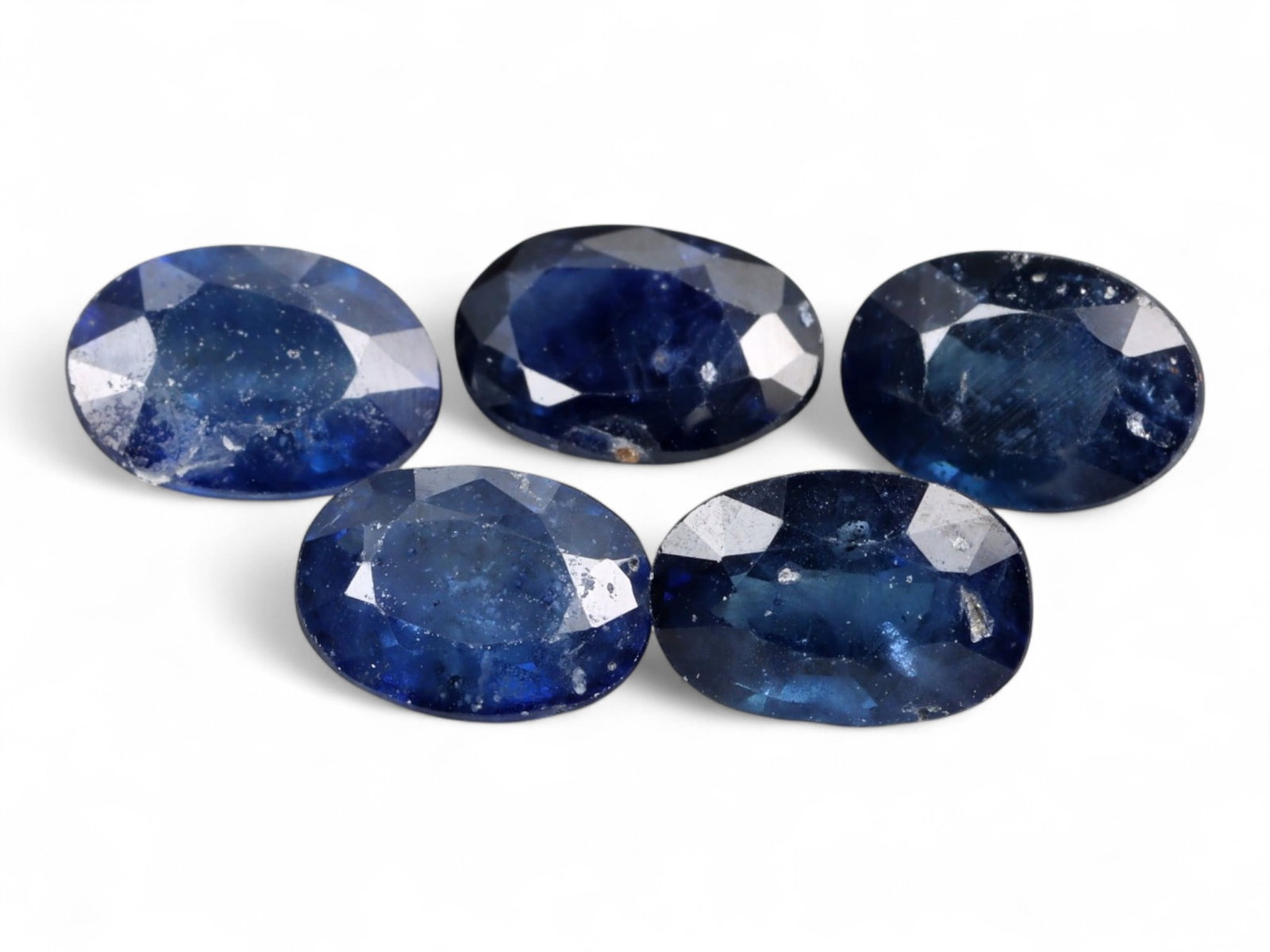 4.75 Carats Royal Blue Sapphire Oval Lot - Natural Ceylon Stones: This captivating lot of oval-cut sapphires exhibits a deep royal blue color, rich and even, with flashes of lighter brilliance across the facets. Each stone, measuring approximately 6.9x4.7x3.7mm, is 