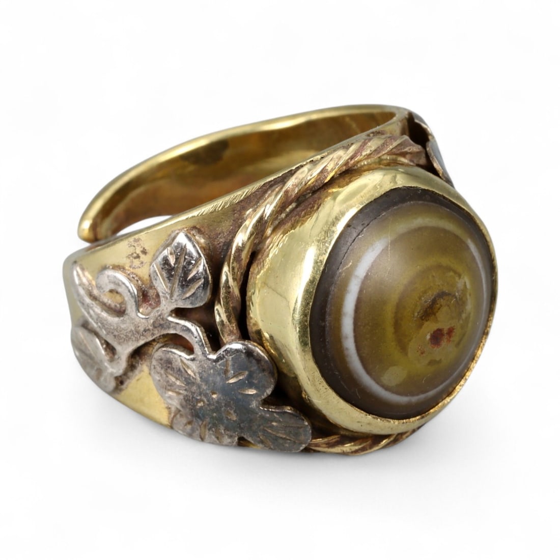 Vintage Himalayan Luk Mik Goat Eye Dzi Silver Gilt Ring, 20th Century: This powerful Himalayan ring, crafted in the 20th century, is set with a Luk Mik "Goat Eye" dzi stone cabochon in a wide silver gilt band with silver decorative accents. The dzi stone displays its cha
