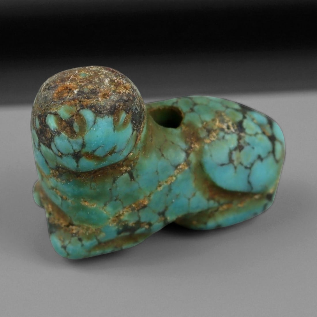 Ancient Persian Turquoise Zoomorphic Amulet, c. 1st Millennium BCE, 1.9cm: This exquisite miniature amulet, carved from natural turquoise and shaped in the form of a reclining animal-possibly a lion or protective feline-originates from ancient Persia, circa 1st millennium BC