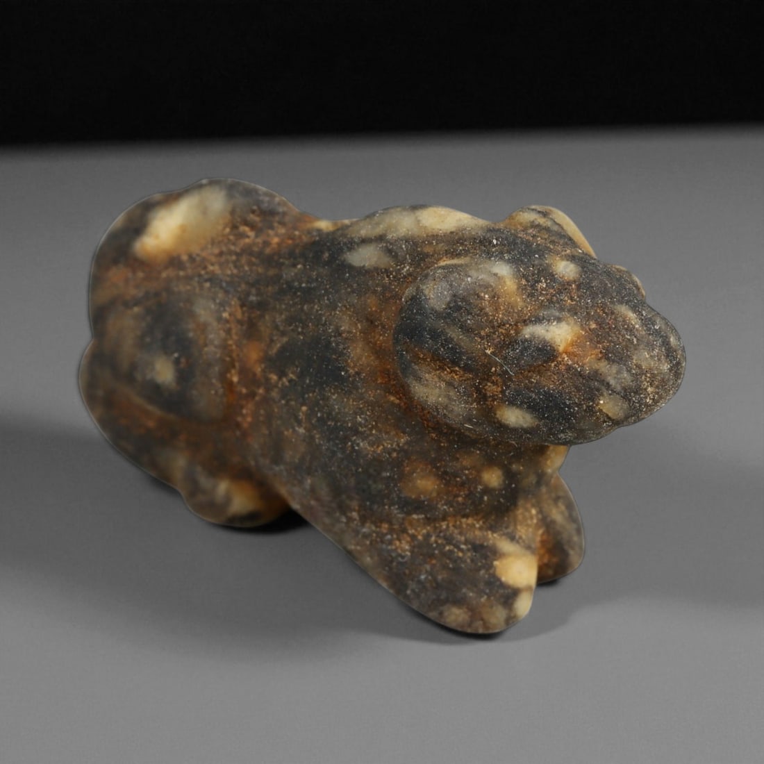 Ancient Near Eastern Feline Amulet in Banded Stone, c. 2nd-1st Millennium BCE, 2.8cm: This small yet striking feline amulet, measuring 2.8 centimeters in length, was carved in the ancient Near East during the 2nd-1st millennium BCE. Rendered from a naturally variegated banded stone of 