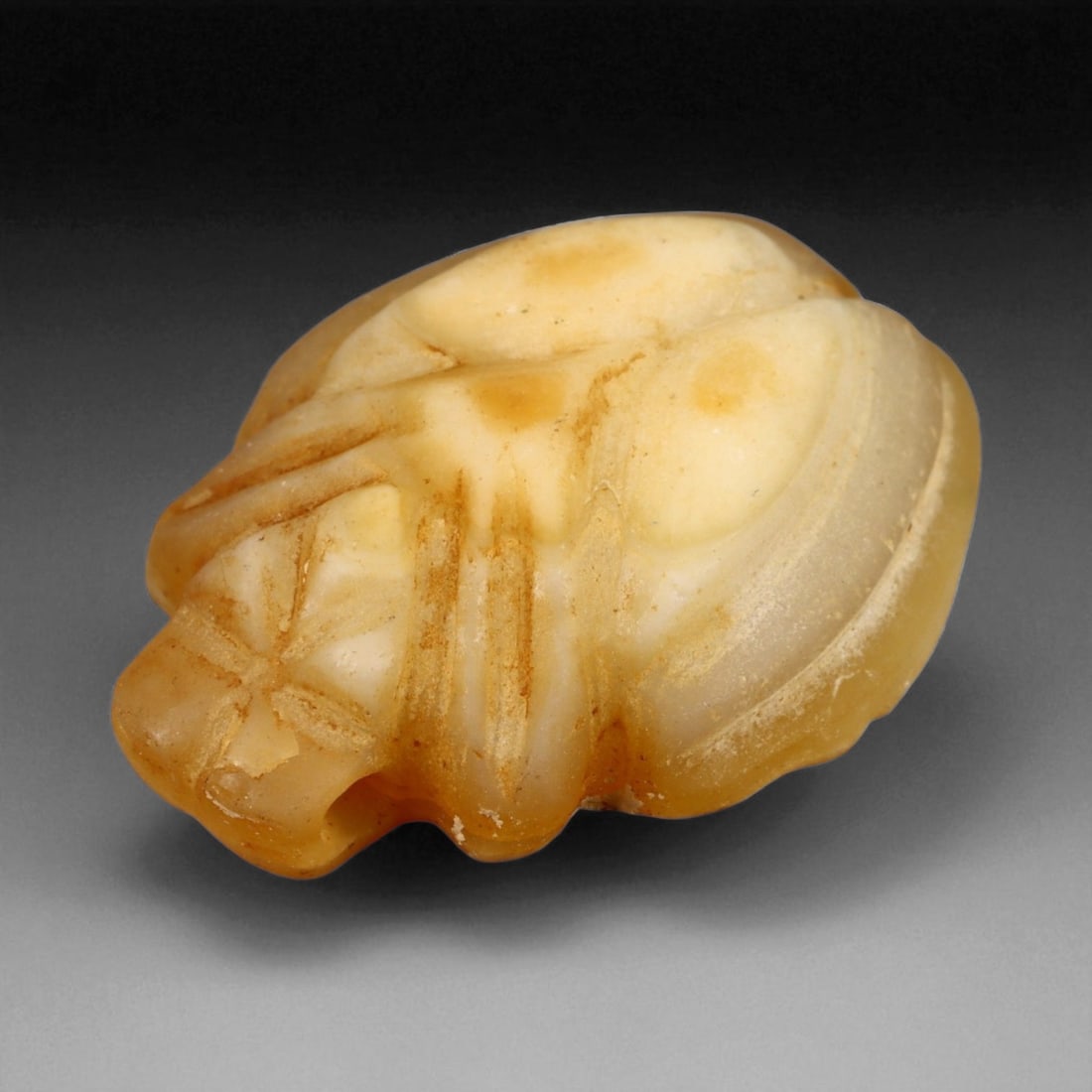 Ancient Egyptian Calcite Fly Amulet, c. 18th Dynasty, New Kingdom 20 mm: This finely carved calcite amulet, in the form of a stylized fly, dates to Egypt's 18th Dynasty, circa 15th-14th centuries BCE. The fly was a revered symbol of courage, persistence, and valor - an emb