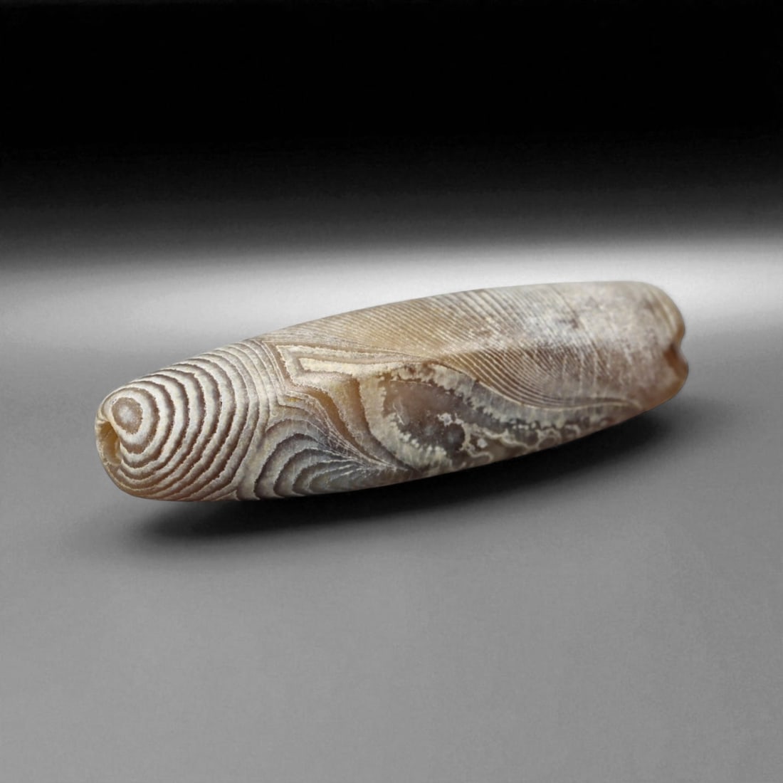 Ancient Persian Banded Agate Bead, Parthian-Roman Period c. 1st-3rd Century CE, 2cm, 0.9g: This elegant banded agate bead, originates from Persia during the Parthian-Roman cultural horizon of the 1st-3rd century CE. Agate, with its natural striations and layered beauty, was one of the most