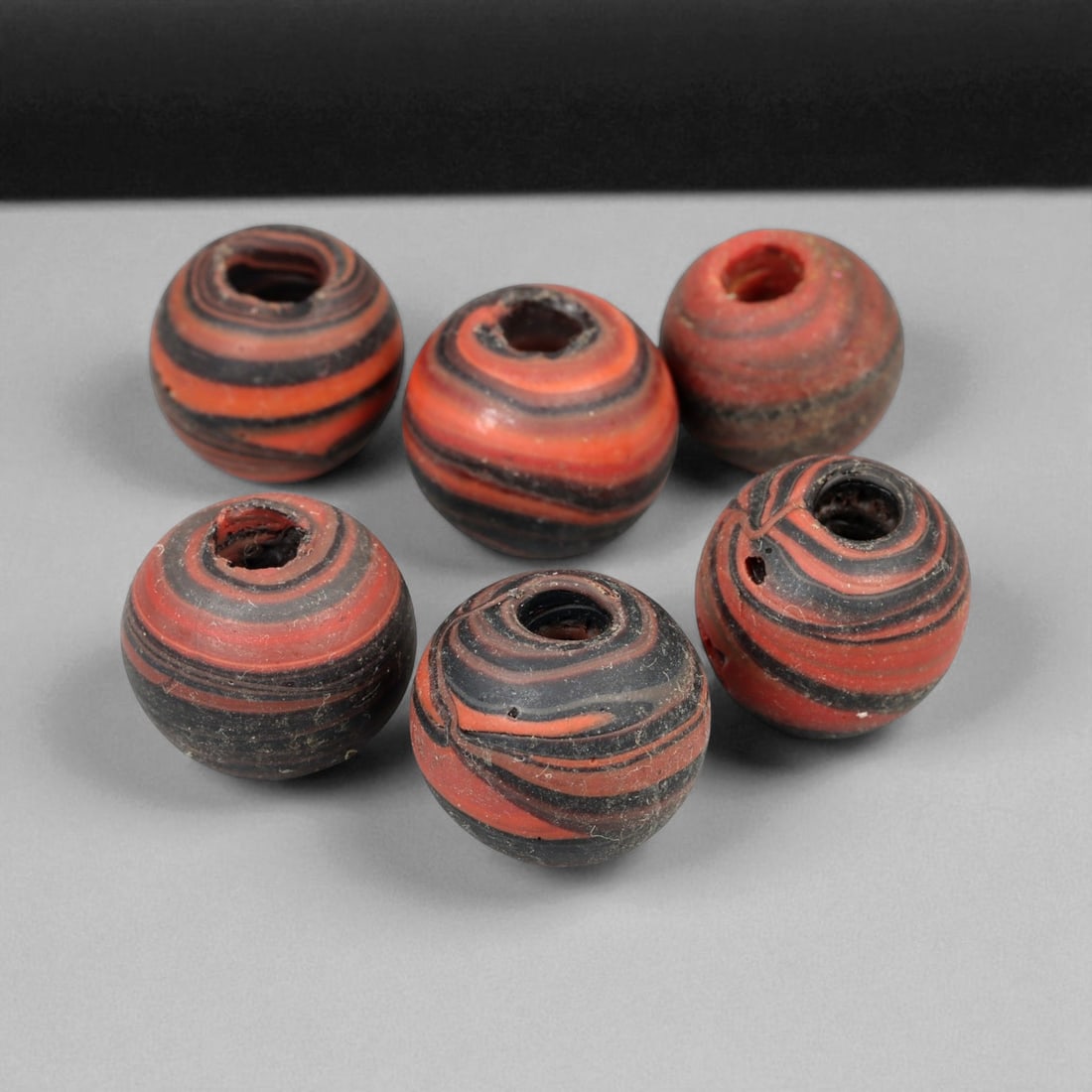 Lot of 6 Medieval Persian Swirl Glass Beads, 13th-14th Century, 1.3-1.5cm, 27g: Vibrant and rhythmically striated, this matched group of six spherical beads exemplifies Persian glasswork from the Islamic Golden Age, likely produced in the 13th-14th century CE. Ranging in diameter
