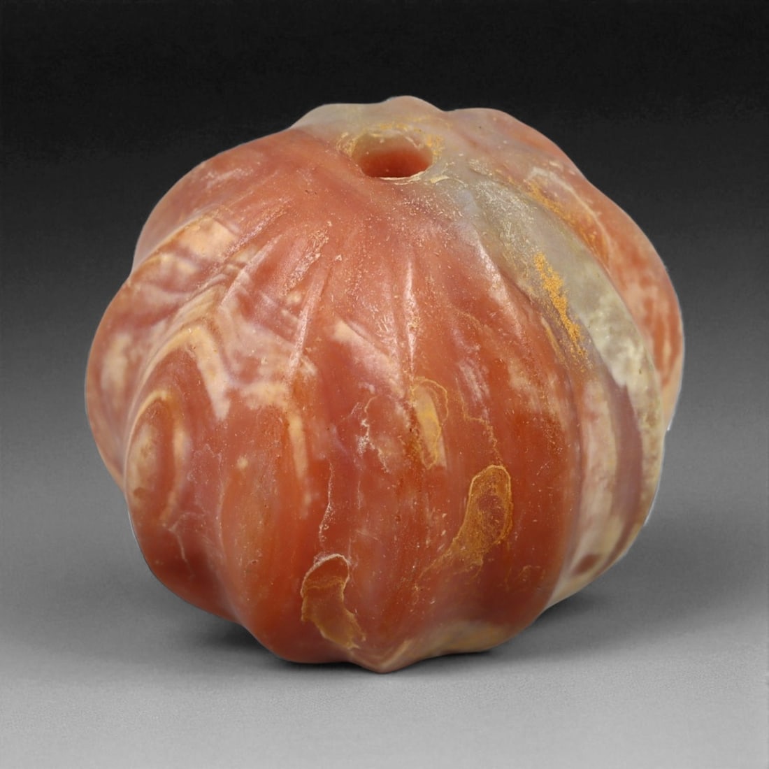 Ancient Sassanian Melon-Shaped Agate Bead, c. 3rd-6th Century CE, 1.7cm, 6.3g: This striking melon-shaped bead, carved from banded agate. The style and craftsmanship are characteristic of the Sassanian Empire (224-651 CE), a period renowned for its refinement of gemstone carving