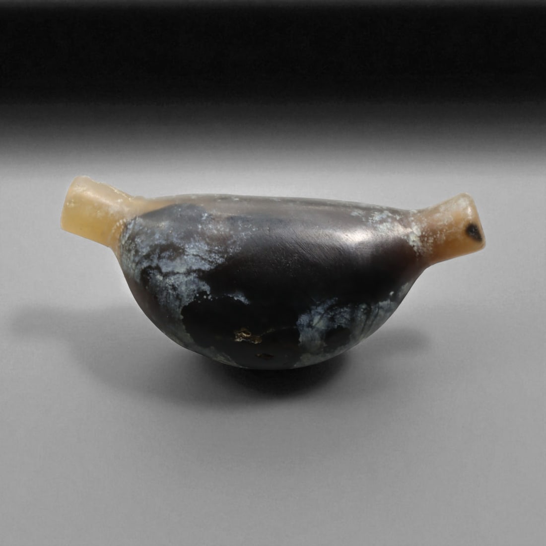 Ancient Persian Achaemenid Agate Bow-Shaped Bead, c. 1st Millennium BC, 3.7cm, 8g: This finely crafted bow-shaped bead, carved from dark banded agate with lighter terminals. Its smooth curvature and carefully drilled perforation mark it as a product of the advanced lapidary traditio